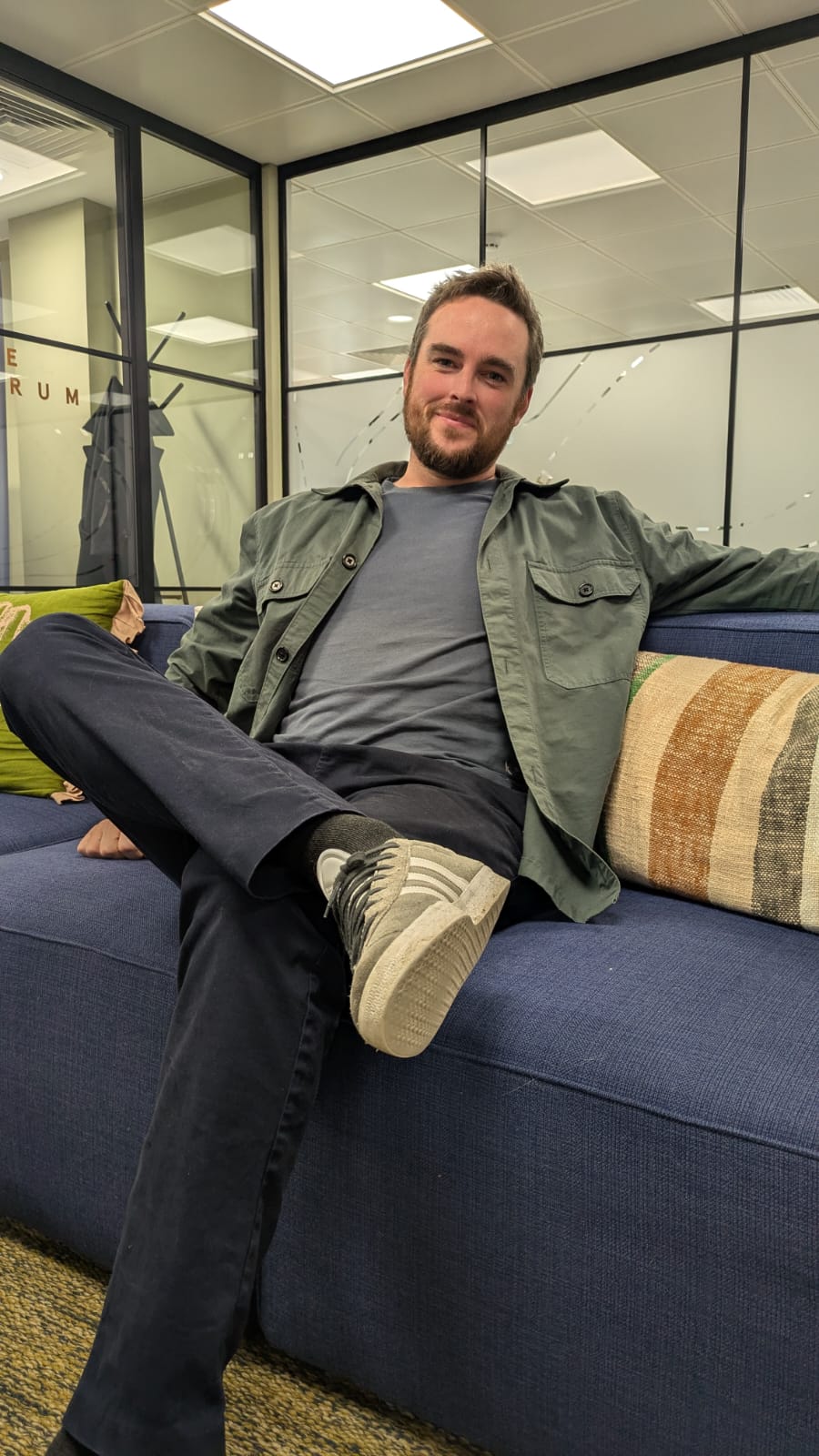George Ledden, the freelancer behind Verdant Digital, sitting on a sofa in an office lounge