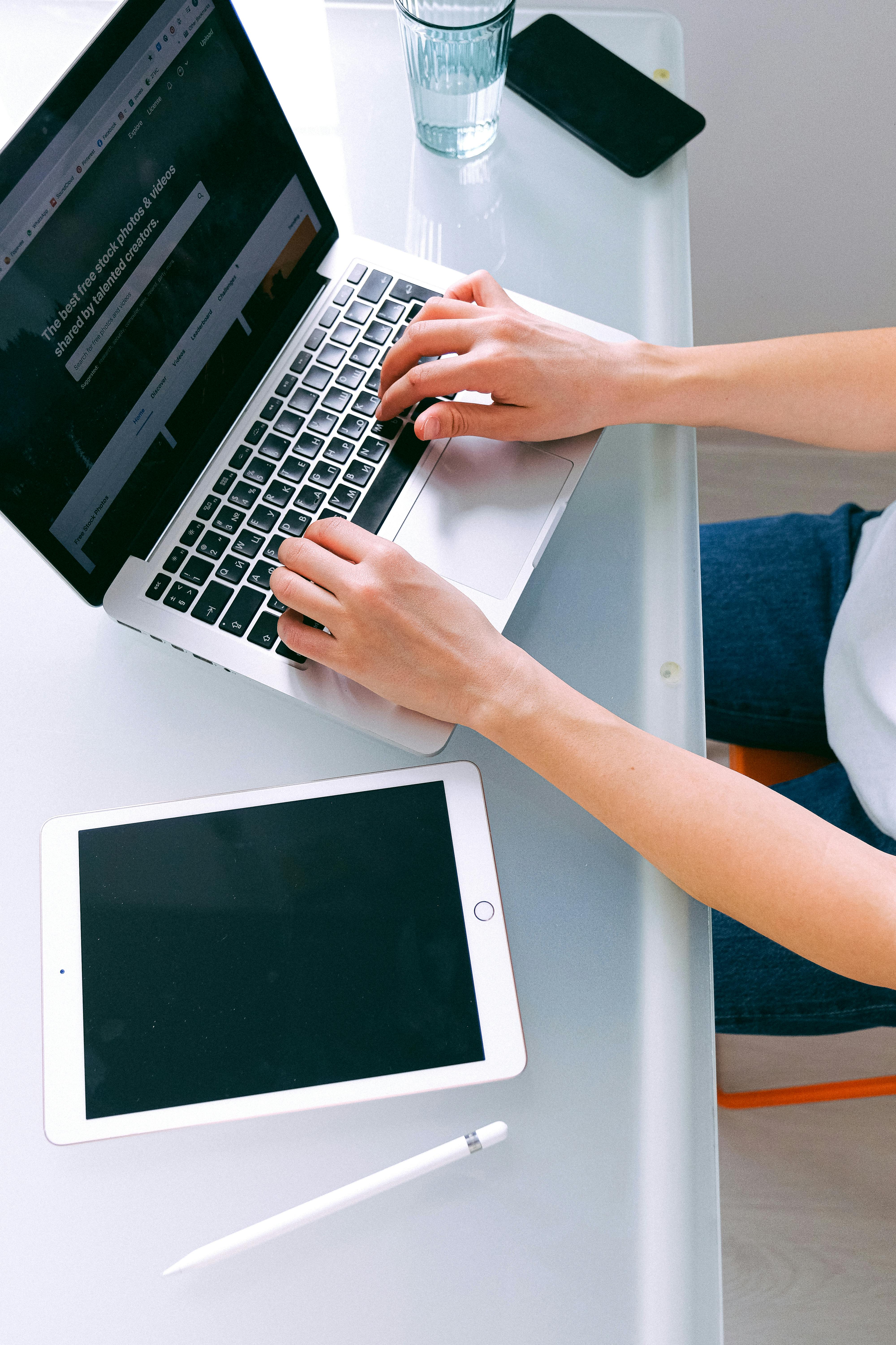 A freelancer working alone at a desk with a laptop and tablet