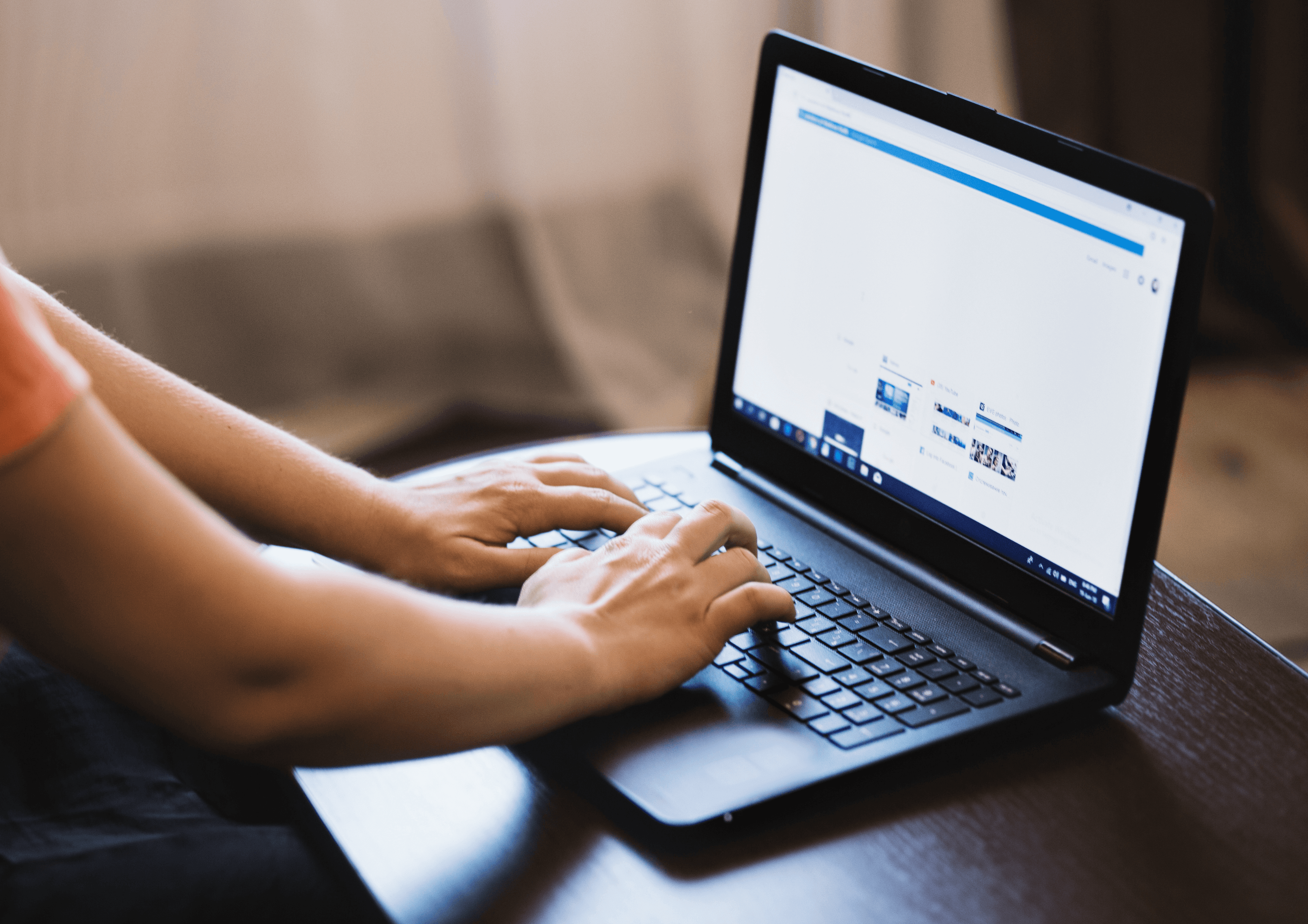 Hands typing on a laptop with a website open in the browser