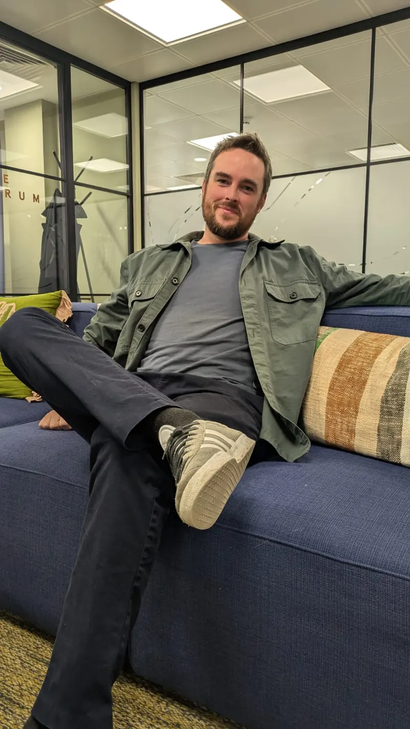 George Ledden, the freelancer behind Verdant Digital, sitting on an office sofa